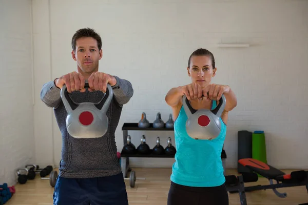 Atletas confiantes levantando kettlebells — Fotografia de Stock