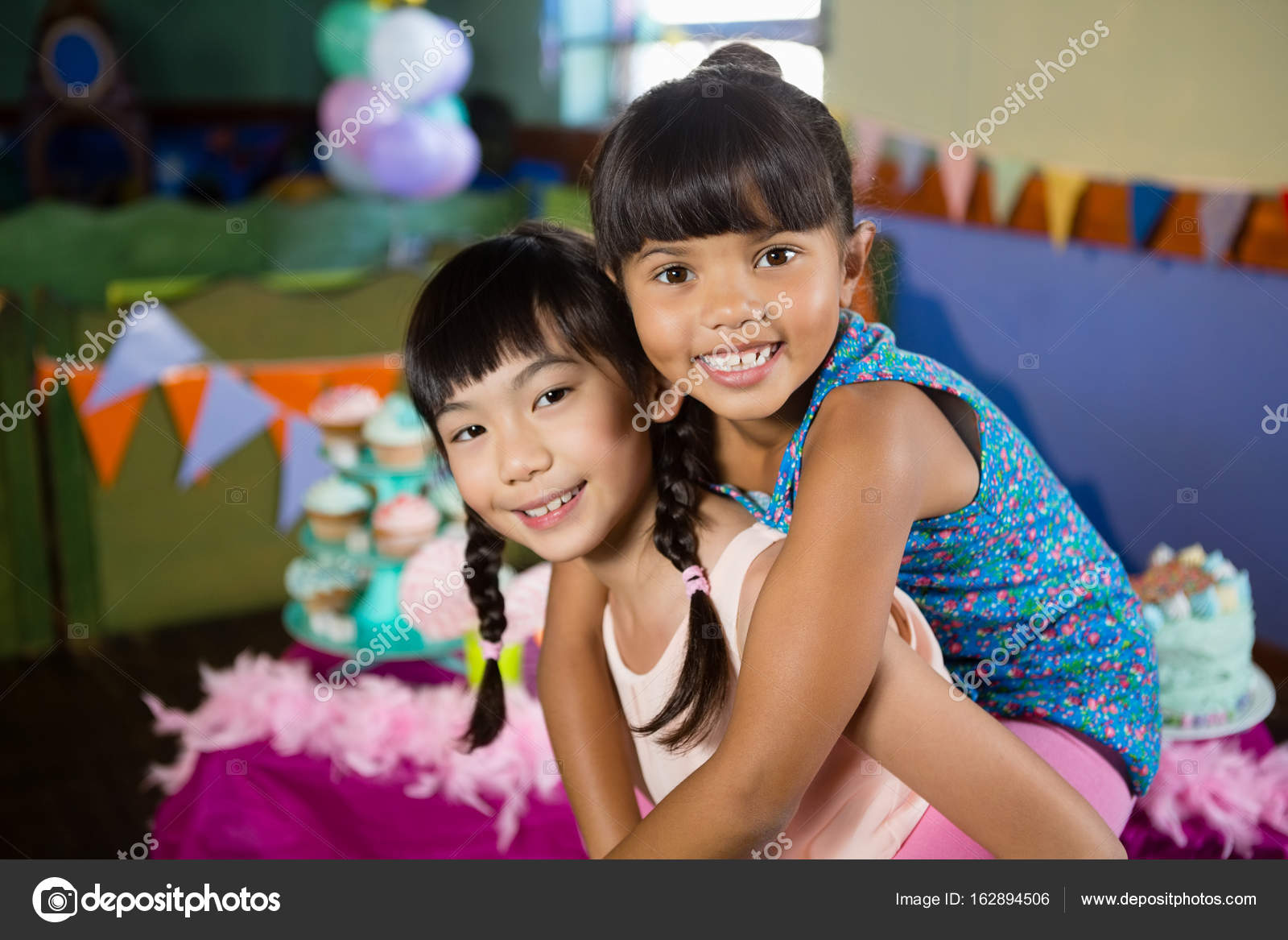 Girl giving her friend a piggyback ride stock photo