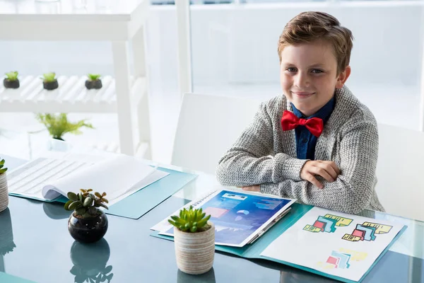 Jongen zit aan de balie in kantoor — Stockfoto