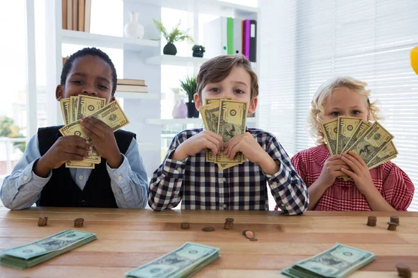 Дети держат валюту за столом — стоковое фото