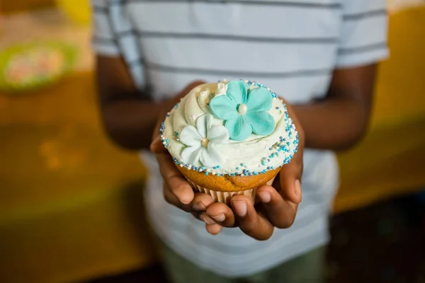 Pojke innehav dekorerad cupcake — Stockfoto