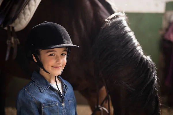 Дівчина в шоломі стоїть з конем — стокове фото