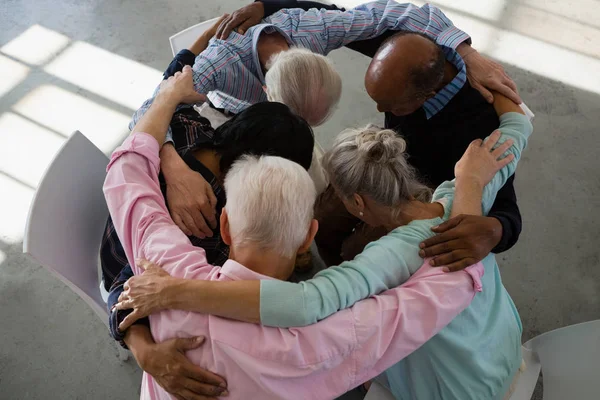 Senior vrienden huddling — Stockfoto