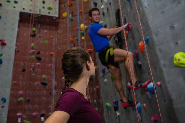 Duvar tırmanma eğitmen seyir atlet — Stok fotoğraf