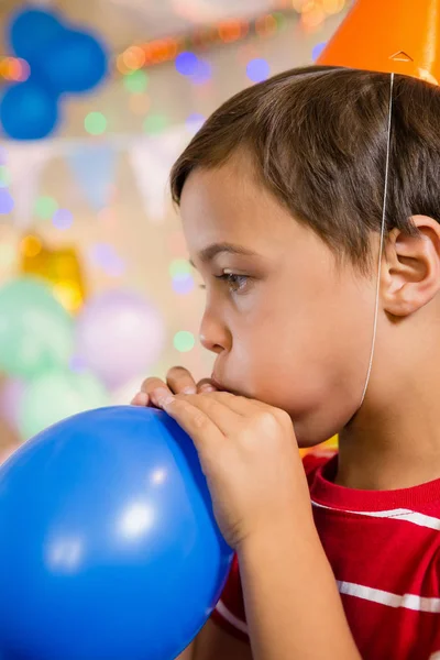 Carino ragazzo soffiaggio palloncino — Foto Stock