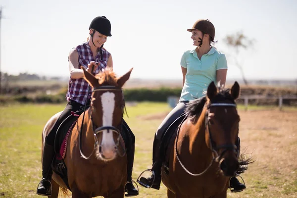 Friends talking while horseback riding — Stock Photo, Image