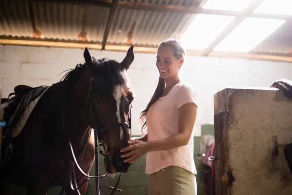 Feminino jockey stroking cavalo — Fotografia de Stock
