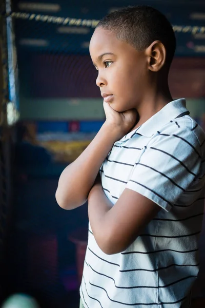 Przemyślane chłopiec stojący w pobliżu okna — Zdjęcie stockowe
