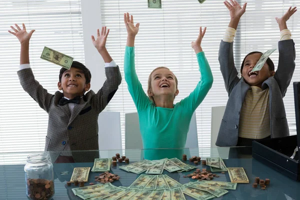 Cheerful business kids throwing currency — Stock Photo, Image