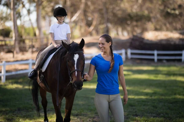 Feminino jockey segurando freio com irmã — Fotografia de Stock
