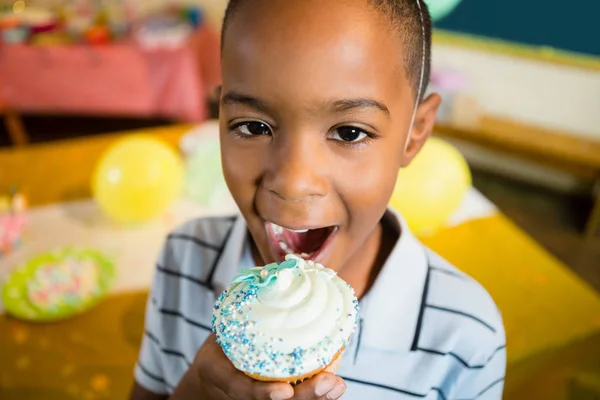 Lindo chico comer cupcake —  Fotos de Stock