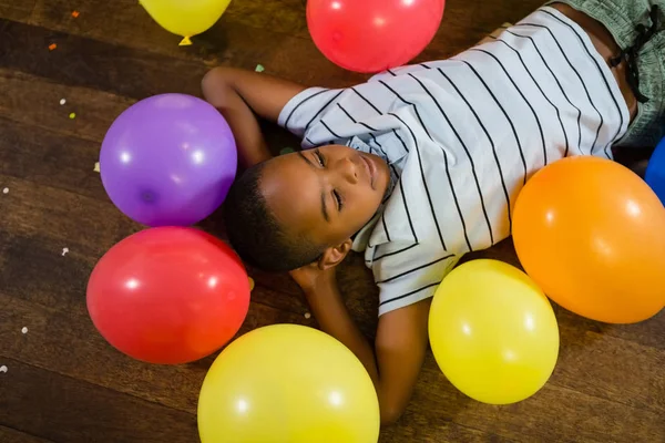 Cute boy relaxing on wooden floor