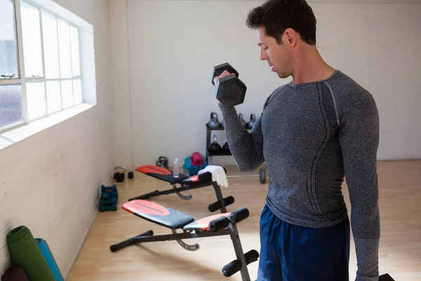 Athlète masculin flexion des muscles dans la salle de gym — Photo