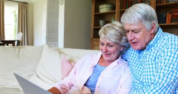 Ανώτερος ζευγάρι χρησιμοποιώντας φορητό υπολογιστή στο σαλόνι — Αρχείο Βίντεο