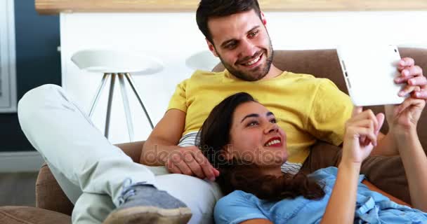 Couple using digital tablet on sofa — Stock Video