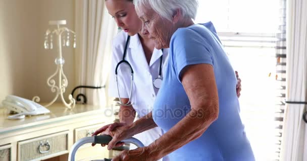 Arzt hilft Seniorin beim Gehen — Stockvideo