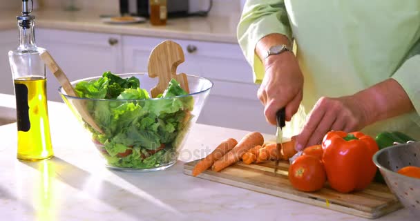 Femme coupant des carottes sur planche à découper — Video