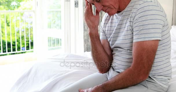 Homme âgé inquiet assis sur le lit dans la chambre — Video