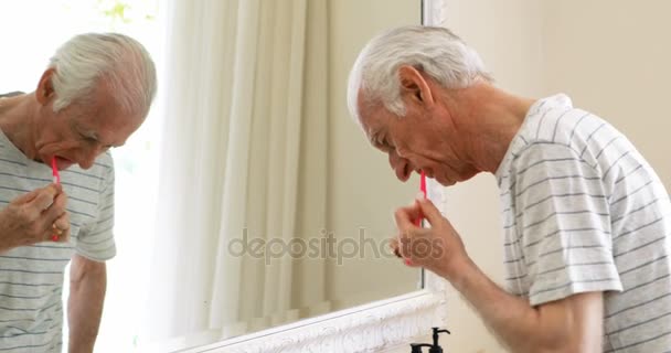 Hombre mayor cepillarse los dientes con cepillo de dientes en el baño — Vídeo de stock