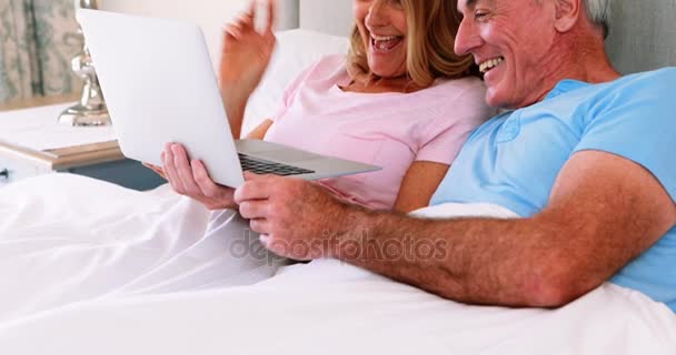 Ευτυχισμένο ζευγάρι ανώτερος στο κρεβάτι που χρησιμοποιούν φορητό υπολογιστή — Αρχείο Βίντεο