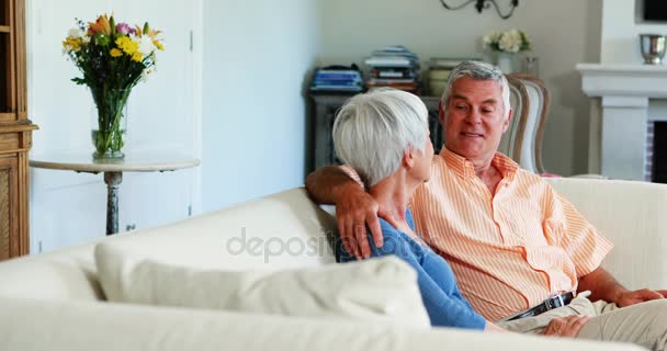 Старшая пара взаимодействует друг с другом на диване — стоковое видео