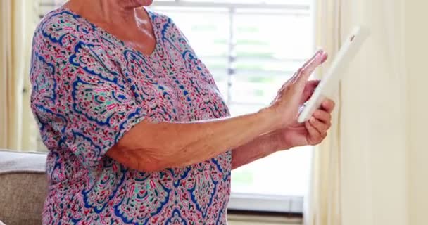Ηλικιωμένη γυναίκα που χρησιμοποιεί ψηφιακό δισκίο — Αρχείο Βίντεο