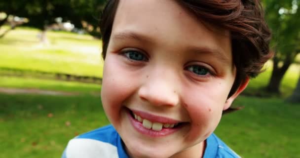 Портрет улыбающегося мальчика в парке — стоковое видео