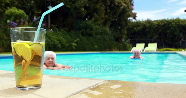 Mujer tomando un vaso de té helado en la piscina — Vídeos de Stock