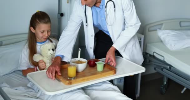 Médico sirviendo comida a chica enferma — Vídeos de Stock