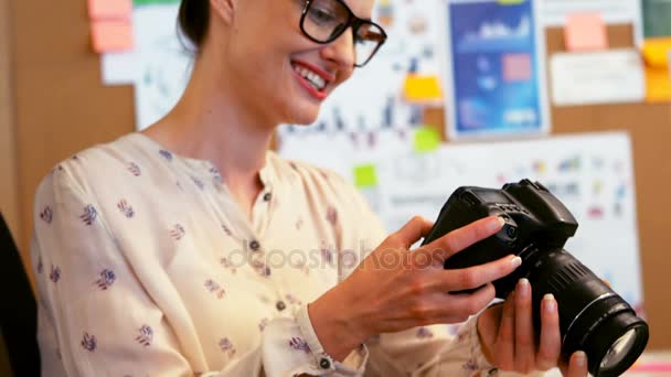 Grafik, patrząc na cyfrowy aparat fotograficzny — Wideo stockowe