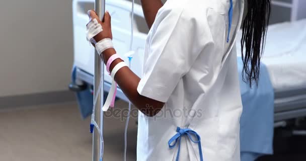 Portrait of sick girl holding iv drip stand — Stock Video