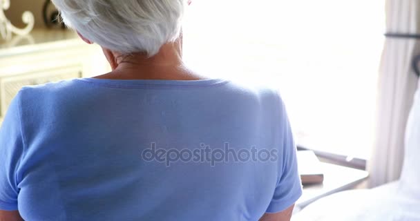 Mujer mayor mirando por la ventana — Vídeos de Stock