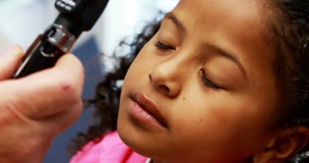 Médecin examinant les yeux des patients avec otoscope — Video