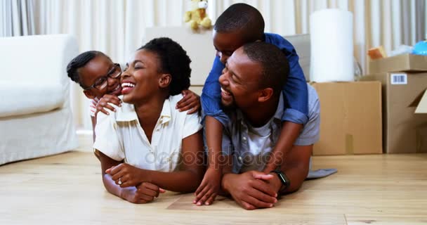 Kinderen liggend op ouders terug in woonkamer — Stockvideo