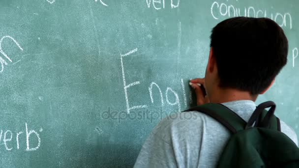 Schooljongen Engels woord op een schoolbord schrijven — Stockvideo