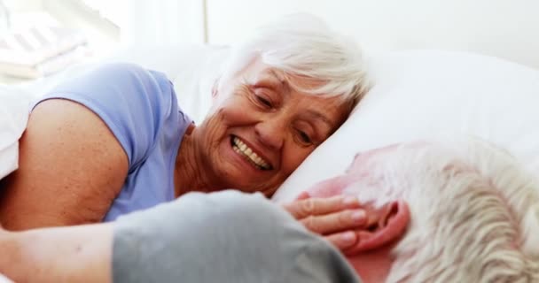 Feliz casal sênior interagindo uns com os outros enquanto deitado na cama — Vídeo de Stock