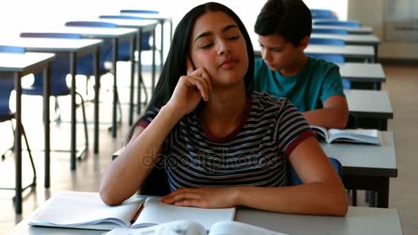 Menina relaxante na mesa enquanto estuda em sala de aula — Vídeo de Stock