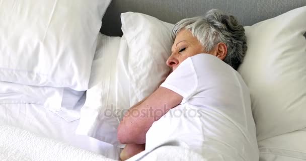 Пожилая женщина спит на кровати в спальне — стоковое видео