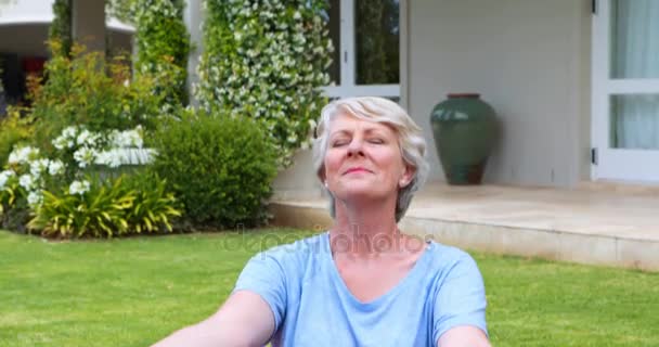 Donna anziana che esegue yoga in giardino — Video Stock