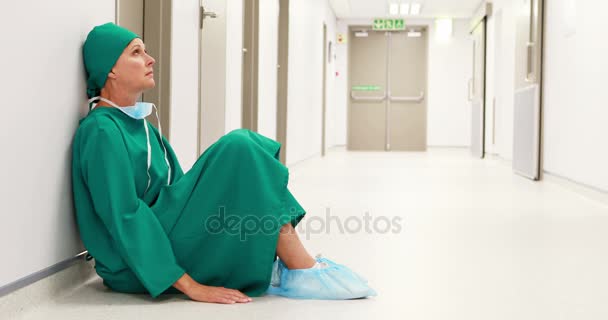 Spända kirurg sitter i korridoren — Stockvideo