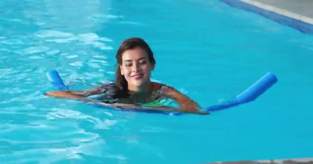 Женщина плавает с надувной трубкой в бассейне — стоковое видео