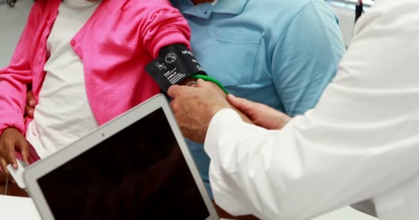 Médico revisando la presión arterial del paciente — Vídeo de stock