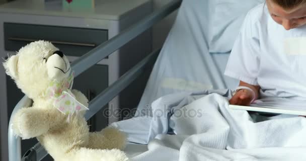 Больная девушка с помощью цифрового планшета на кровати — стоковое видео