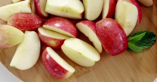 Шматочки червоних яблук і ножа на дошці — стокове відео