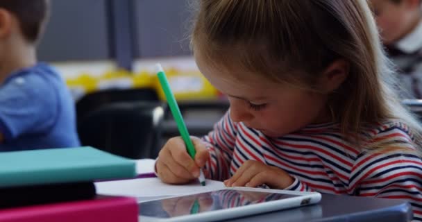 Schattig schoolmeisje tekening van foto's in de klas — Stockvideo