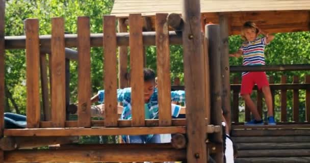 Школярка грає на слайді на ігровому майданчику — стокове відео