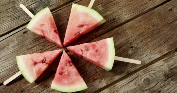 Segmenten van watermeloen gerangschikt op houten tafel — Stockvideo