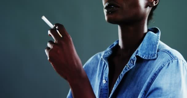 Androgynous man posing with cigarette against dark background — Stock Video