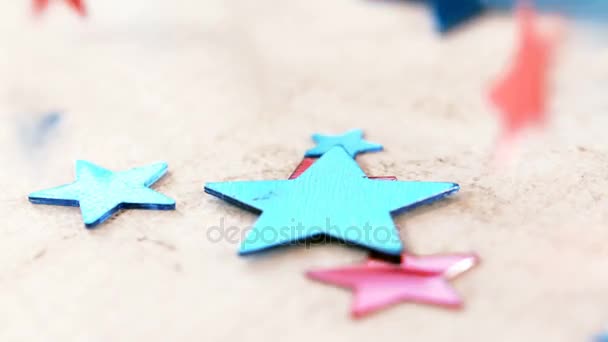 Star shape decorations falling on wooden table — Stock Video