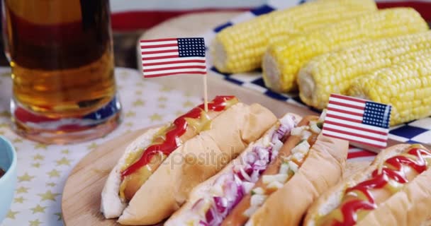 Perros calientes en mesa de madera con tema del 4 de julio — Vídeo de stock